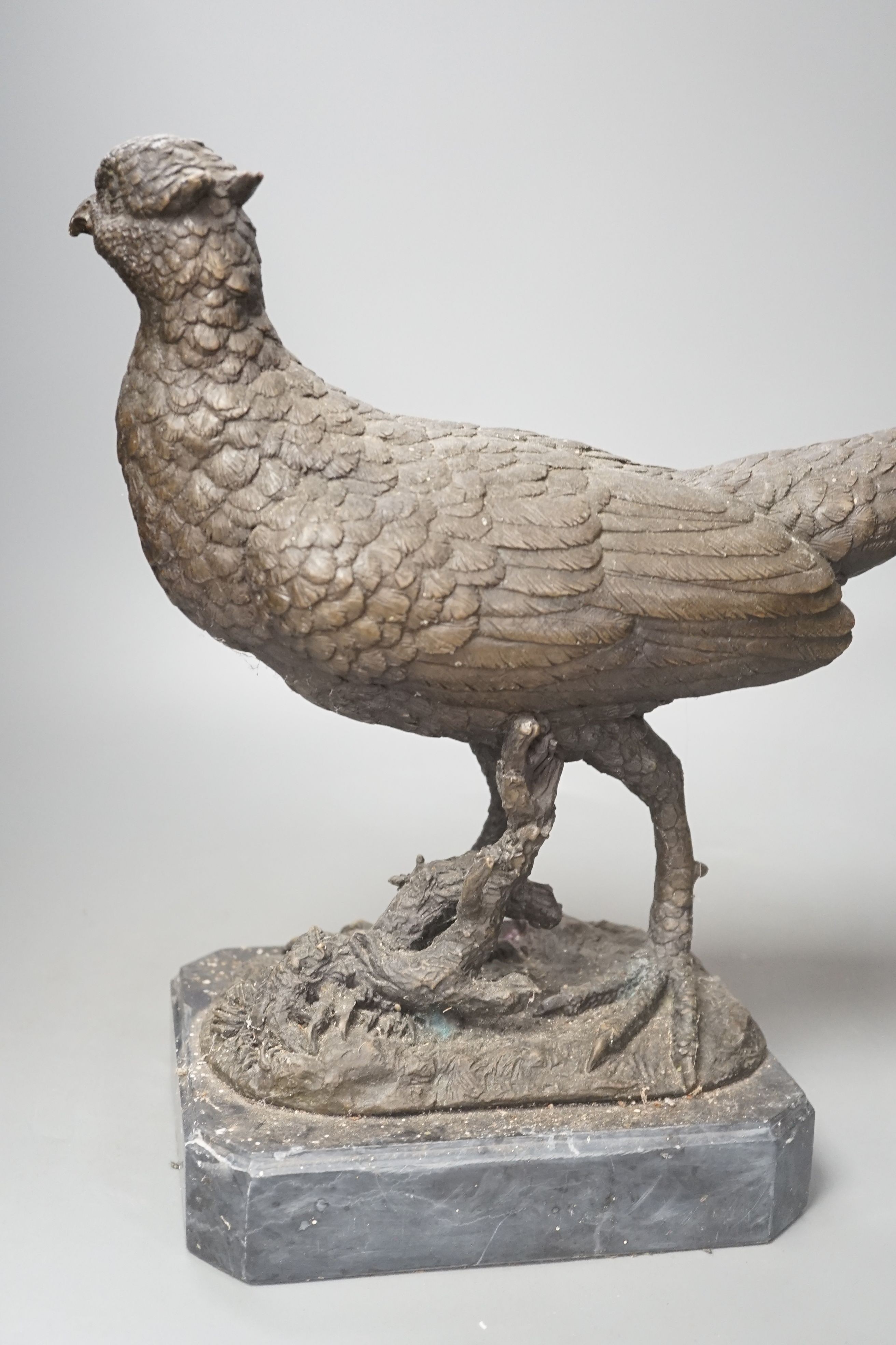 A bronzed metal pheasant, indistinctly signed, on marble base. Length 51cm